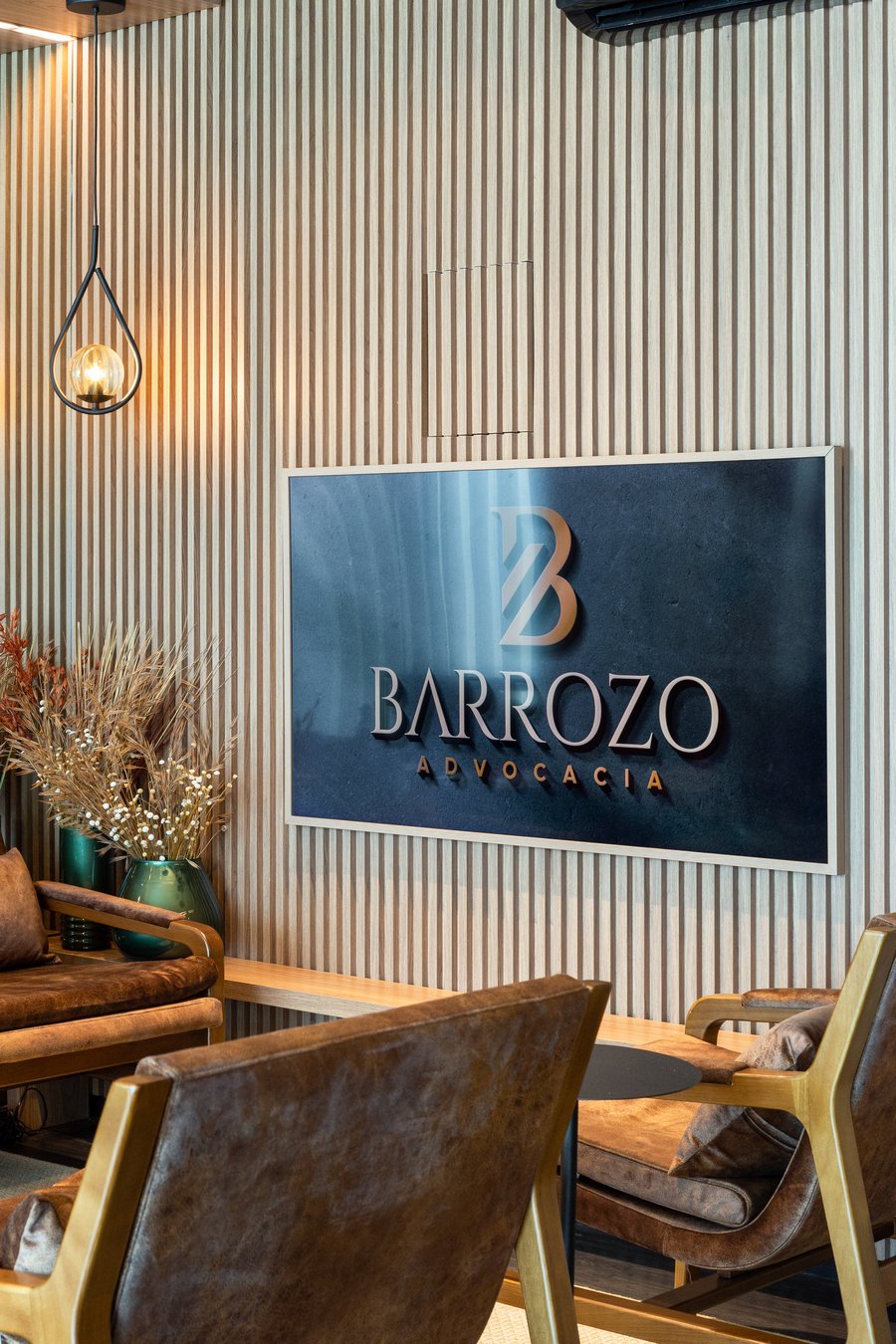 Painel da marca Barrozo Advocacia em parede ripada de madeira